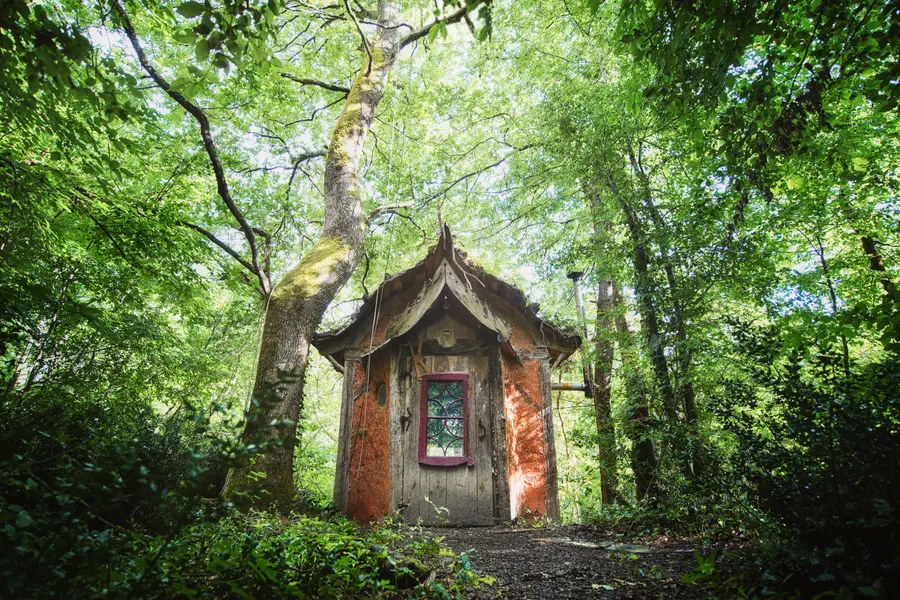 Une cabane aux murs rouges dans la forêt