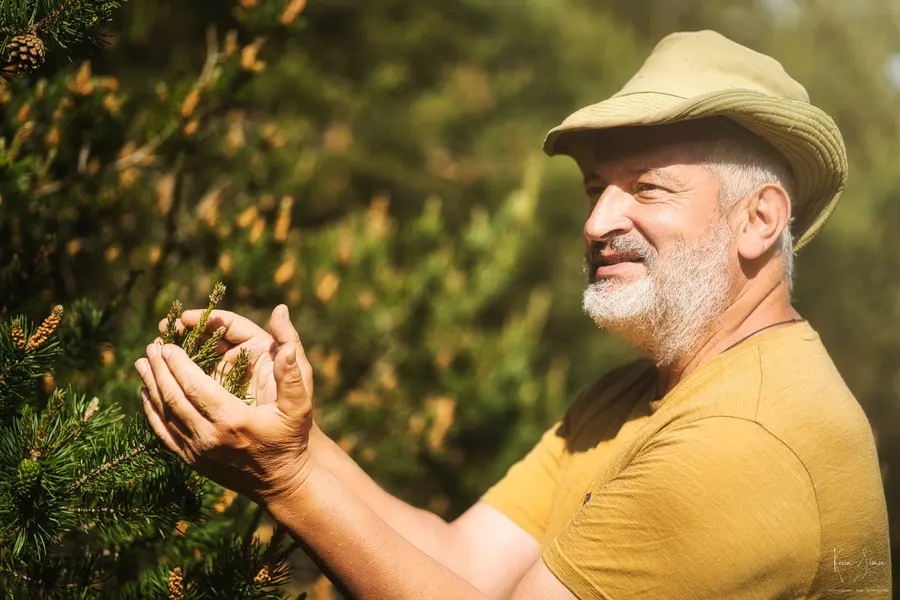Un paysan au chapeau tient de la terre dans ses mains