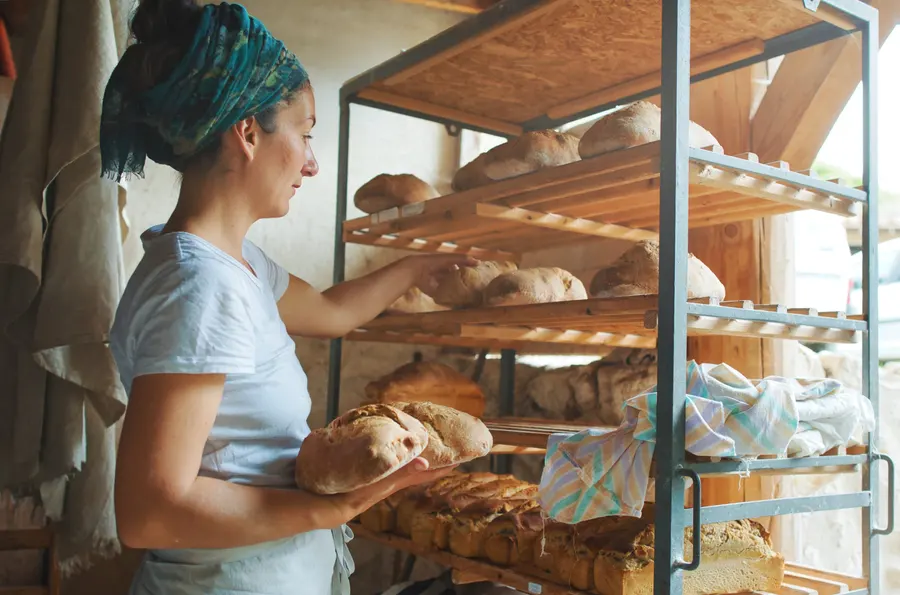 Une boulangère range ses pains sur une étagère