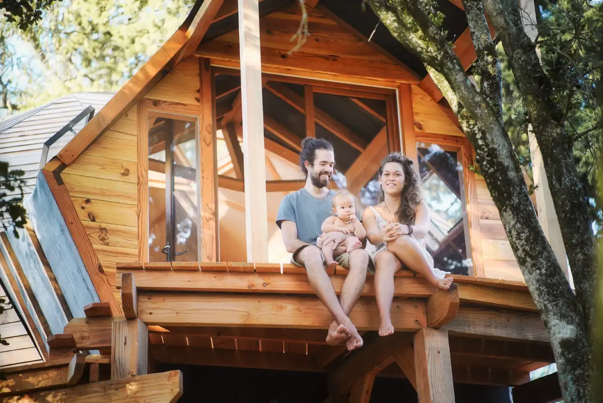 Une famille assise sur la terrasse d’une maison en bois